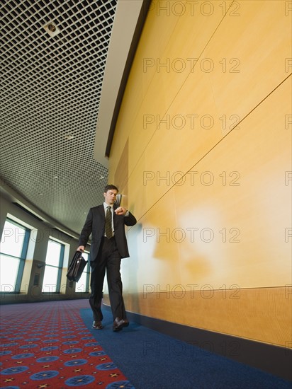Businessman checking watch in corridor. Date : 2008