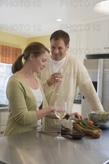 Couple making dinner in kitchen. Date : 2008