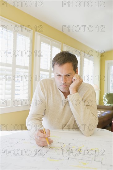 Man reviewing house blueprints. Date : 2008