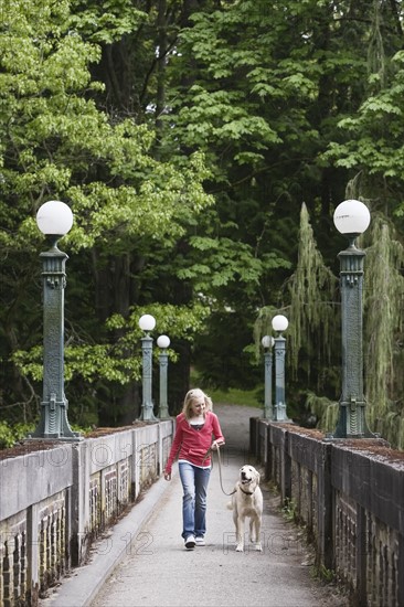 Girl walking dog across bridge. Date : 2008