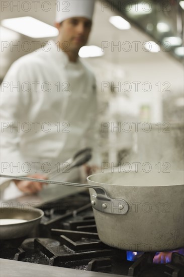 Chef and steaming pot on stove. Date : 2008