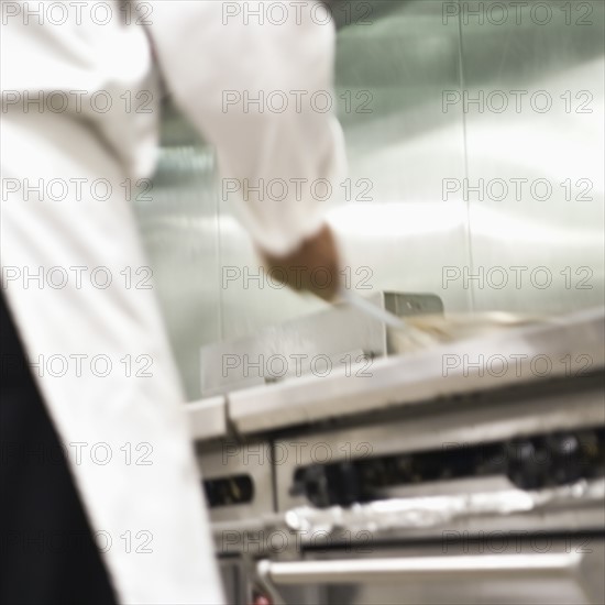 Chef shaking pan on stove. Date : 2008
