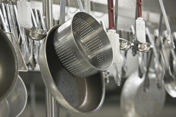 Pots and cooking utensils hanging from rack. Date : 2008