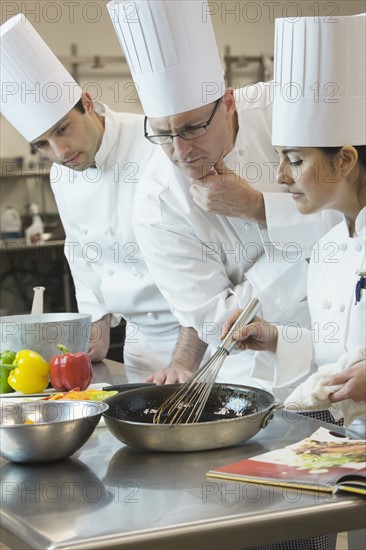 Head chef inspecting cooking techniques. Date : 2008