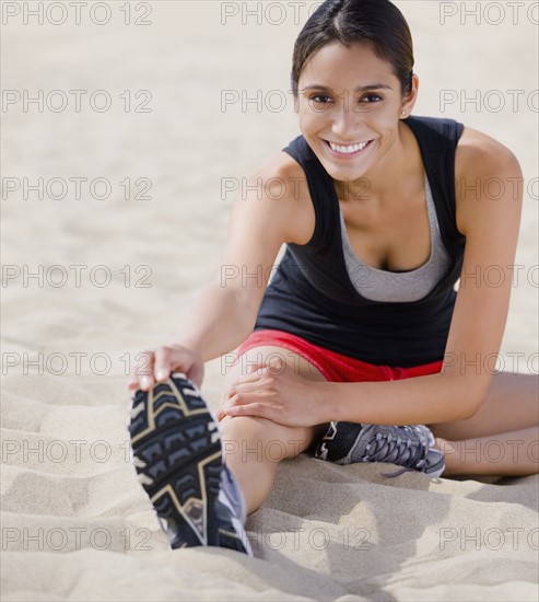 Runner stretching on beach. Date : 2008