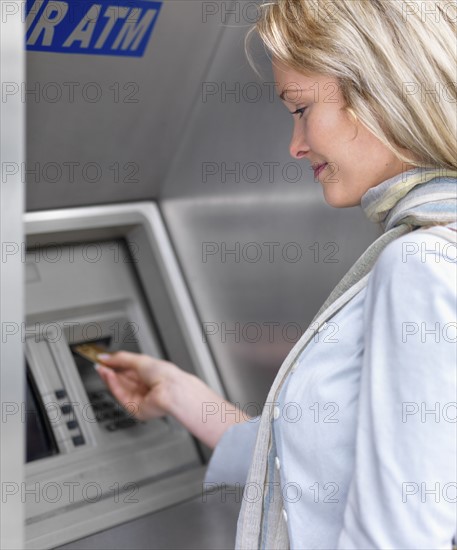 Woman using cash machine. Date : 2008