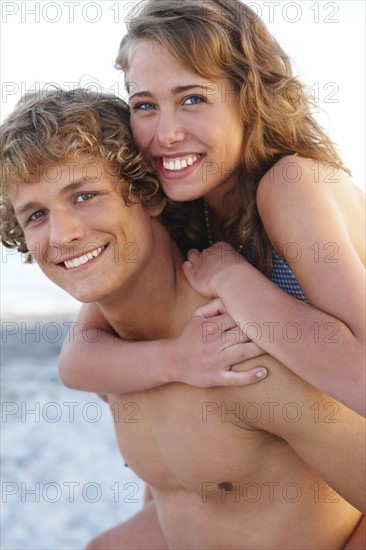 Young man carrying girlfriend on back. Date : 2008