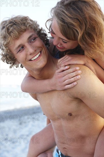 Young man carrying girlfriend on back. Date : 2008