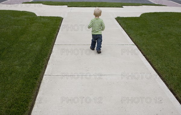 Baby boy walking on sidewalk. Date : 2008