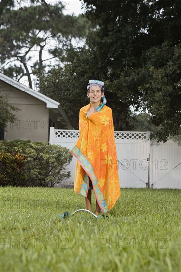 Boy wrapped in towel on lawn. Date : 2008