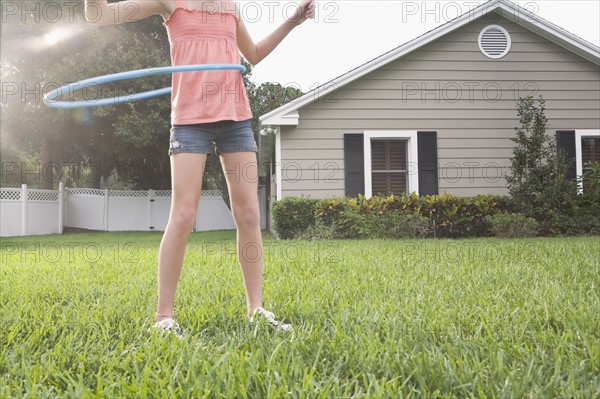 Girl hula hooping in backyard. Date : 2008