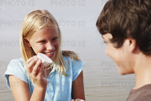 Girl showing shell to friend. Date : 2008