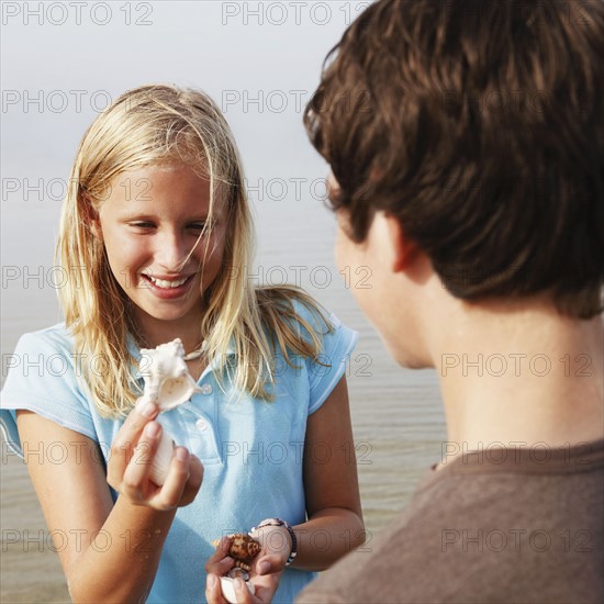 Girl showing shell to friend. Date : 2008