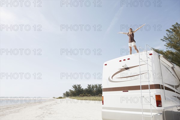 Young woman standing on top of motor home. Date : 2008