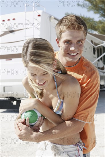 Young couple playing with football on beach. Date : 2008