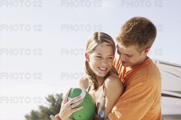 Young couple playing with football on beach. Date : 2008