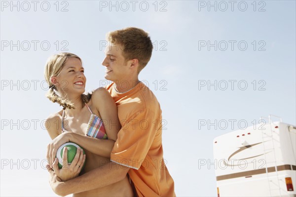 Young couple playing with football on beach. Date : 2008