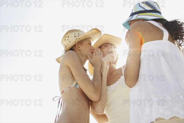 Friends gossiping on beach. Date : 2008