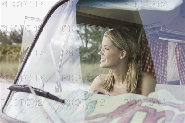 Young woman sitting in van on beach. Date : 2008