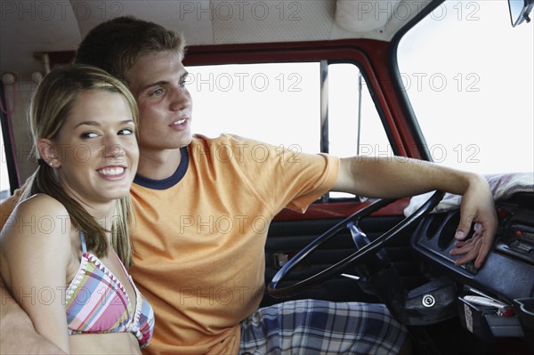 Young couple sitting in van on beach. Date : 2008