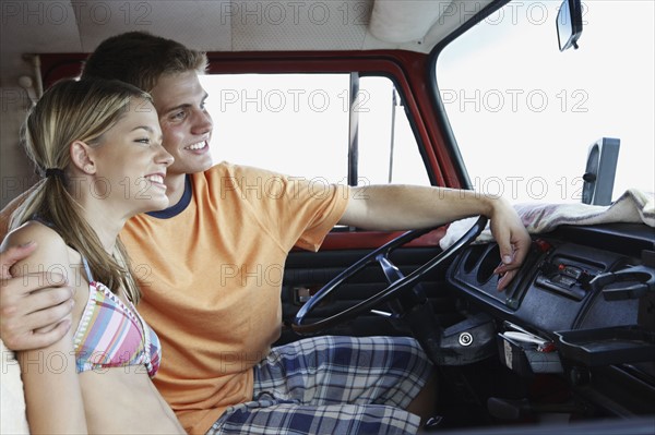 Young couple sitting in van on beach. Date : 2008