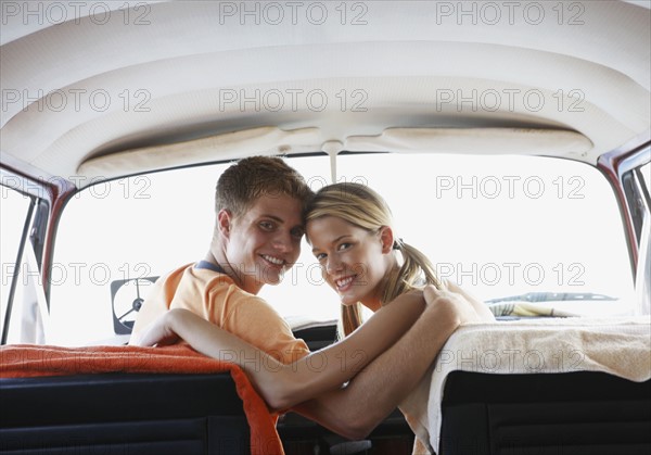 Young couple sitting in van on beach. Date : 2008