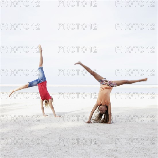 Girls doing cartwheels on beach. Date : 2008