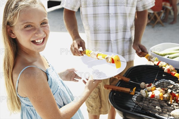 Man grilling dinner for family on beach. Date : 2008