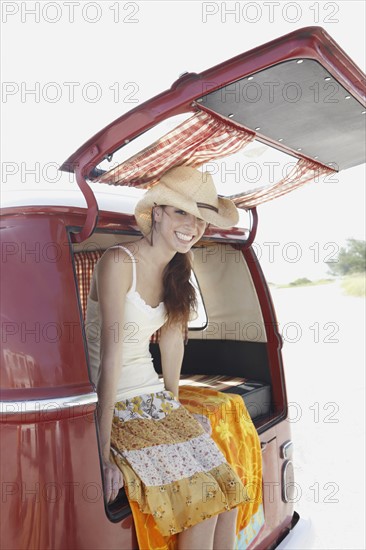 Young woman sitting in van on beach. Date : 2008
