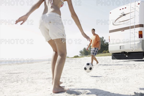 Young couple playing soccer on beach. Date : 2008