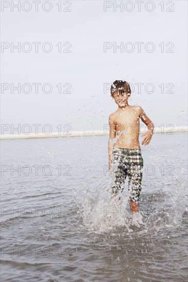 Boy splashing in ocean. Date : 2008