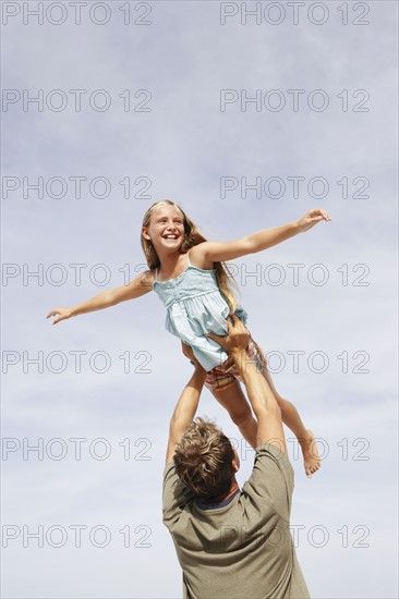 Father lifting daughter in air. Date : 2008