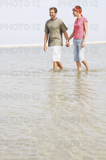 Couple wading in ocean. Date : 2008