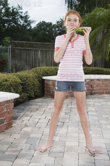 Girl eating watermelon on patio. Date : 2008