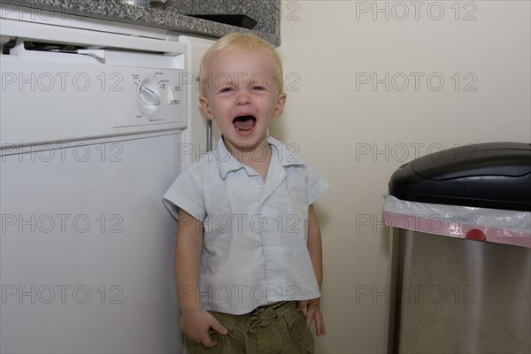 Baby boy crying in kitchen. Date : 2008