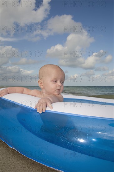 Baby boy sitting in inflatable swimming pool. Date : 2008