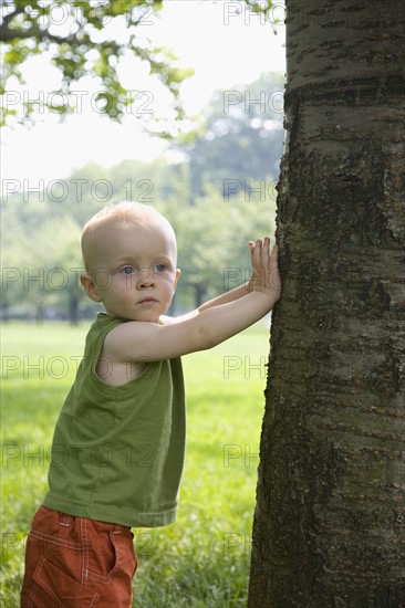 Baby boy leaning against tree. Date : 2008