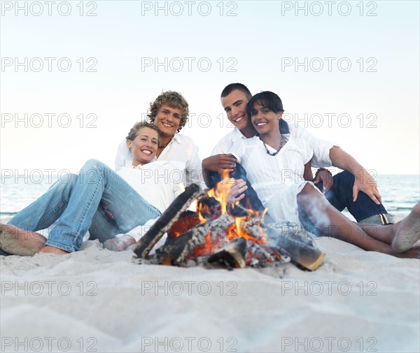 Young couples hugging by campfire on beach. Date : 2008