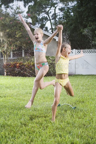 Girls running through sprinklers. Date : 2008