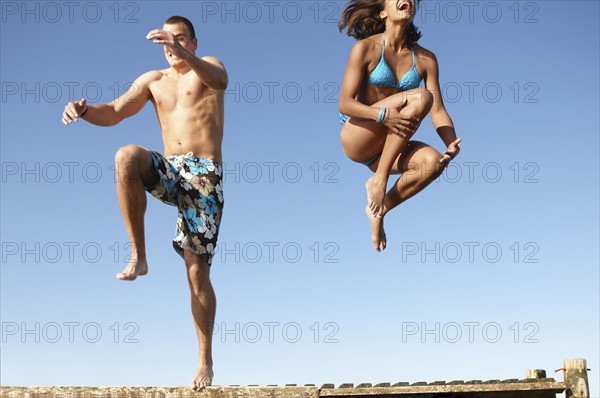 Young couple jumping of dock. Date : 2008