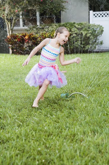 Girl running through sprinkler. Date : 2008