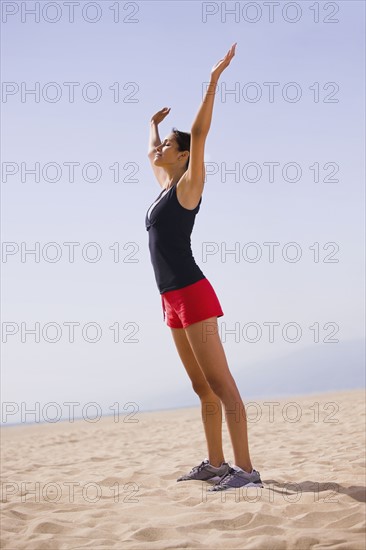 Runner stretching on beach. Date : 2008