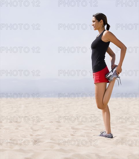 Runner stretching on beach. Date : 2008