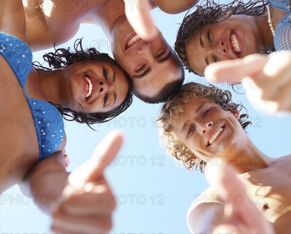 Low angle view of young friends in huddle. Date : 2008