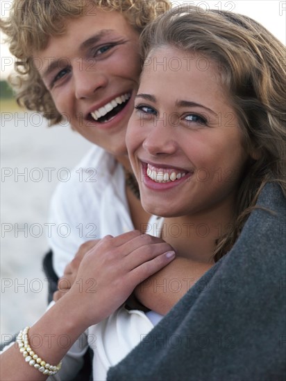 Young couple wrapped in blankets on beach. Date : 2008