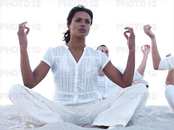 Young people doing yoga on beach. Date : 2008