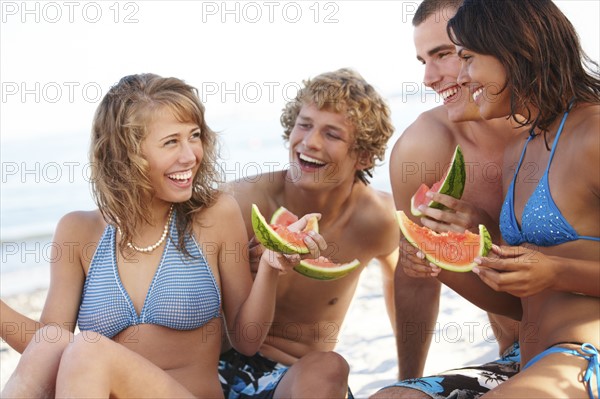 Young couples eating watermelon on beach. Date : 2008