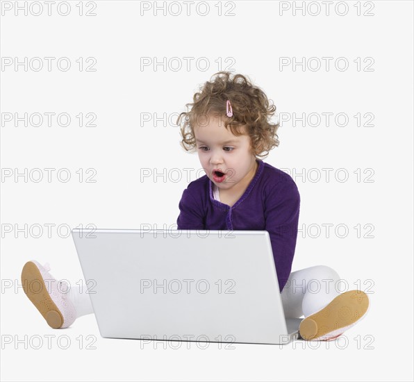 Preschool girl playing with laptop. Date : 2008