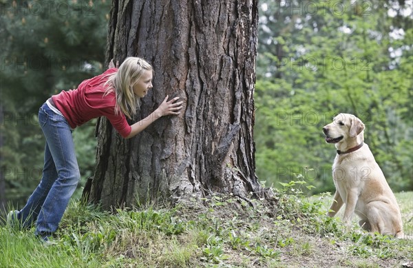 Girl playing hide and seek with dog. Date : 2008