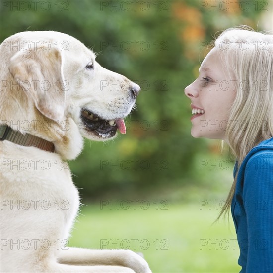 Girl and dog face to face. Date : 2008